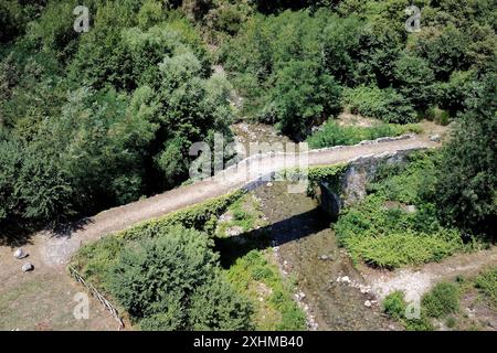 Scigliano, Italie. 12 juillet 2024. Dans la province de Cosenza, en Calabre, une petite ville appelée Scigliano est traversée par la rivière Savuto, au-dessus de laquelle se trouve l'ancien Ponte di Annibale ou Ponte di S. Angelo. Diverses preuves archéologiques montrent que le pont, aujourd'hui monument historique national, est en cours de construction entre 131 et 121 av. J.-C., et est l'un des plus anciens ponts d'Italie. (Photo de Massimo Valicchia/NurPhoto) crédit : NurPhoto SRL/Alamy Live News Banque D'Images