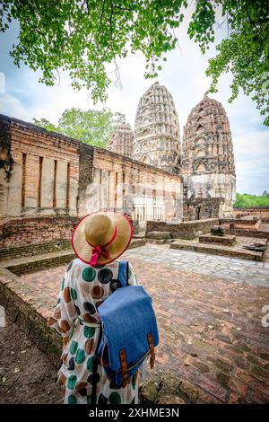 Femme avec chapeau et sac à dos admirant le temple Wat si Sawai, Thaïlande Banque D'Images
