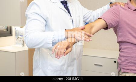 L'invention concerne un traumatologue effectuant un test de mouvement du bras sur un patient dans le cadre d'une consultation médicale. Banque D'Images