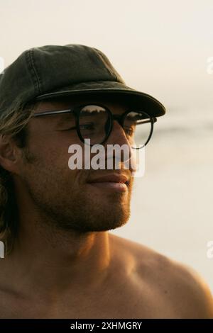 Homme heureux au coucher du soleil sur la plage de l'océan. Banque D'Images