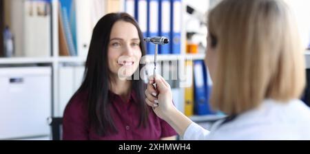 Neurologue médecin outil de marteau de conduite devant les yeux du patient en clinique Banque D'Images