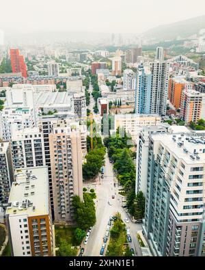 Vol aérien au-dessus de nouveaux immeubles de maisons de blocs immobiliers modernes sur les toits et les rues avec des voitures dans le district de Saburtalo, la capitale de la Géorgie Tbilissi. Urbain Banque D'Images