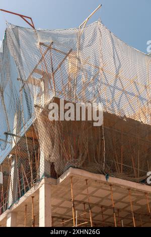 Procédé de construction de nouveaux bâtiments. Les filets de sécurité et les poutres structurelles soulignent les travaux en cours. Plan détaillé de l'architecture à plusieurs niveaux. Idéal pour Banque D'Images