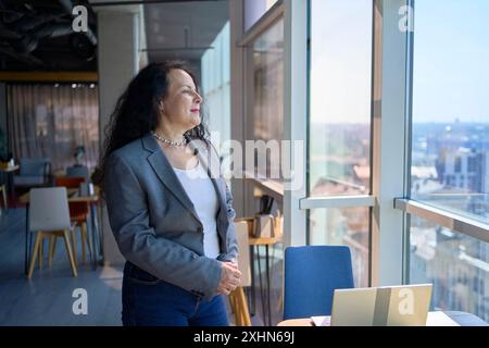 une femme de 57 ans travaille sur un ordinateur portable dans un espace de travail moderne Banque D'Images