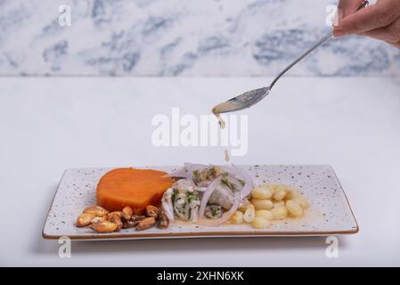 Cuillère versant le jus du plat traditionnel péruvien appelé ceviche. Banque D'Images