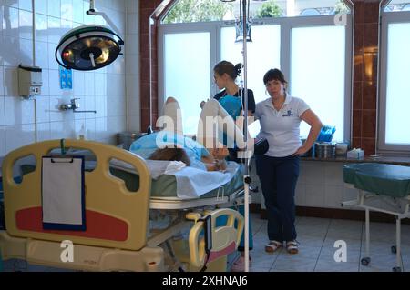 En salle d'accouchement. Femme accouchant couchée sur la chaise, les médecins prêts à accoucher. 25 juin 2019. Kiev, Ukraine Banque D'Images