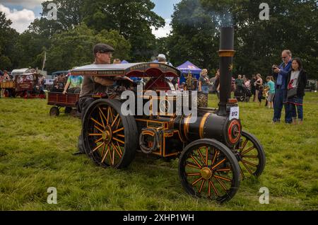 Storrington / Royaume-Uni - 13 juillet 2024 : un passionné de vapeur conduit son modèle réduit de moteur de traction à vapeur à Sussex Steam Fair, Parham, Storrington, Royaume-Uni. Banque D'Images