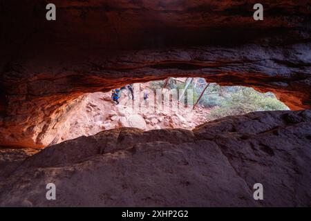 Sedona, Arizona - 10 mars 2024 : à l'intérieur de la grotte Soldier Pass, regardant les randonneurs ci-dessous Banque D'Images