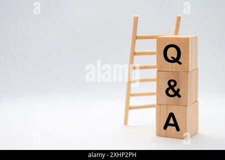 Texte de question et réponse sur cubes en bois avec fond d'échelle en bois Banque D'Images