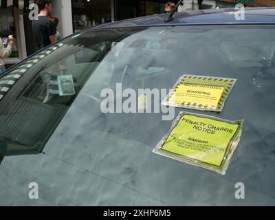 Avis de pénalité de stationnement collés sur le pare-brise d'une voiture pour infraction aux restrictions de stationnement. Salcombe, Devon, Royaume-Uni Banque D'Images