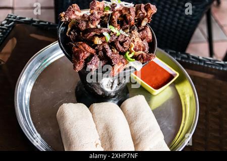 Shekla Tibs est un savoureux repas national éthiopien de viande sautée et d'épices, traditionnellement servi dans un pot en argile avec de l'injera Banque D'Images