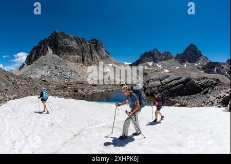 France, Savoie, Valmeinier, massif du Thabor, trek autour du Thabor, au col de Chaval blanc, groupe de randonneurs sur un petit lac partiellement couvert de sn Banque D'Images