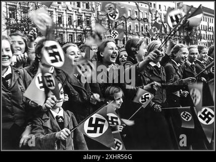 ANSCHLUSS AUTRICHE ANNEXION NAZIE FILLES SWASTIKA DRAPEAUX des années 1930 Allemagne nazie la Ligue des filles allemandes ou la bande des jeunes filles allemandes (allemand : Bund Deutscher Mädel, abrégé en BDM) L'aile des filles du mouvement de jeunesse du parti nazi, la Jeunesse hitlérienne. Aussi Jungmädelbund ('Ligue des jeunes filles') pour les filles âgées de 10 à 14 ans, toutes agitant joyeusement des drapeaux swastika nazis 1938 Banque D'Images