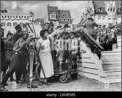 LENI RIEFENSTAHL réalisatrice allemande de propagande nazie Leni Riefenstahl (1902-2003) lors du tournage du film Triomphe de la volonté en 1934 à Nuremberg, en Franconie, Allemagne. Derrière son caméraman en chef, Sepp Allgeier (1895-1968) l'écoute. Entouré par les rangs de l'armée paramilitaire du parti nazi de Sturmabteilung (Australie méridionale) Banque D'Images