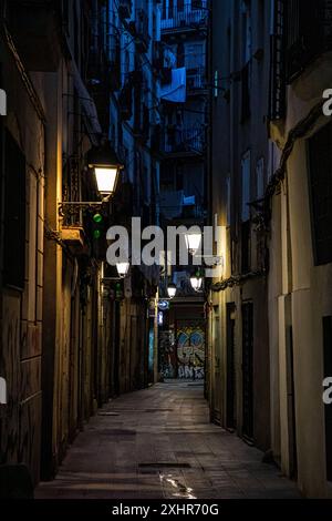 Rue / ruelle sombre, sombre et déserte éclairée par des lampes la nuit Banque D'Images