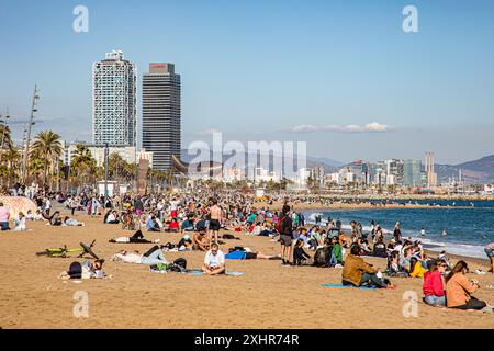 Foules de gens remplissant la plage / assis sur la plage de barceloneta à Barcelone, Espagne, tourisme de masse Banque D'Images