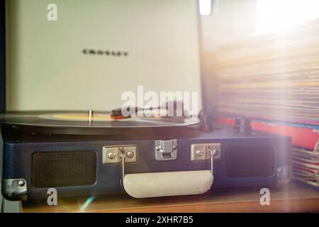 Lecteur de disques vinyles vintage nostalgique à l'ancienne dans un étui avec la lumière du soleil qui coule de la droite Banque D'Images