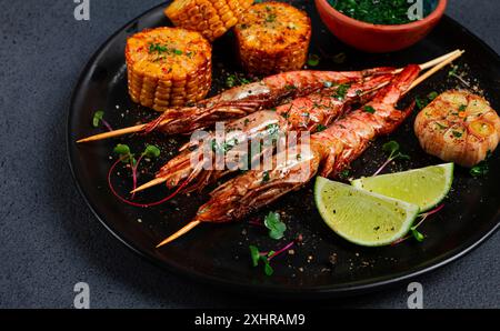 Langoustines sur brochettes, kebab de crevettes, avec maïs frit, épices et herbes, maison, personne Banque D'Images