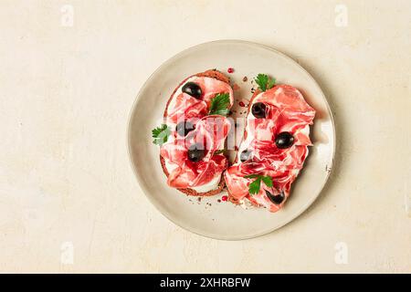 Sandwich au fromage à la crème, prosciutto aux olives, petit déjeuner Banque D'Images