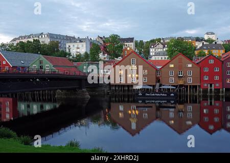 Maisons en bois colorées reflétées dans l'eau dans la soirée, avec pont et architecture de la ville historique, vieux centre-ville, Nidarelva, Trondheim Banque D'Images