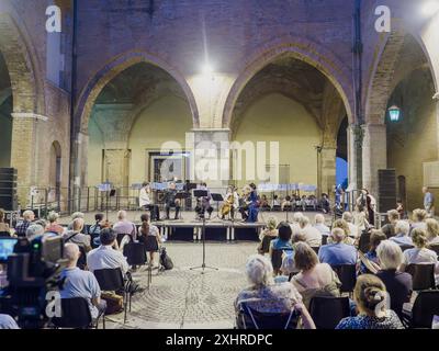 Un concert organisé sous les arcades présente des musiciens interprétant de la musique classique devant un public assis, Cremona, Italie, 28 juin 2024 Miyaji ensemble Banque D'Images