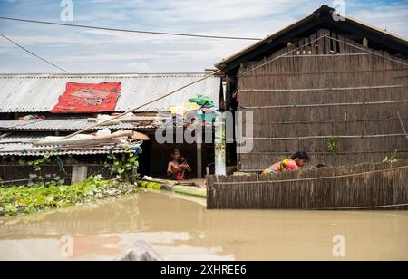 Morigaon, Inde. 4 juillet 2024. Résidents dans leur maison inondée, dans un village touché par les inondations dans le district de Morigaon dans l'État du nord-est de l'Inde Banque D'Images