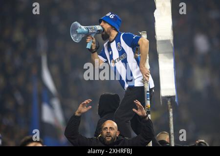 Match de football, un fan du FC Porto avec maillot sur la clôture criant avec un mégaphone, un autre fan du FC Porto ci-dessous avec les bras levés et dans un Banque D'Images