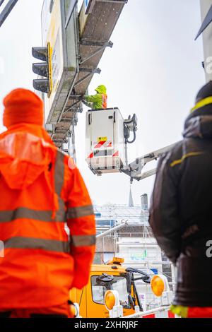 Ouvrier du bâtiment travaillant à une grande hauteur avec une grue sous la pluie sur un chantier, chantier de construction ferroviaire Hermann Hesse, Calw, Noir Banque D'Images