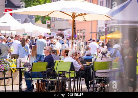 Les gens assis sous des parasols dans un café de rue tandis que d'autres se promènent le long de la rue animée, salon du jardin et de la céramique, Nagold, Forêt Noire, Allemagne Banque D'Images