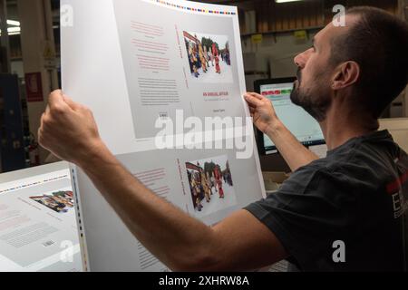 Imprimeurs de livres de photographie d'art italiens, EBS Verona. Imprimante vérifiant la couleur et la qualité d'impression de la couverture d'une affaire annuelle : quelques coutumes traditionnelles du calendrier britannique par Homer Sykes. Les premières feuilles plates sortent de la presse. Années 2024 2020 San Giovanni Lupatoto, Vérone Italie HOMER SYKES Banque D'Images