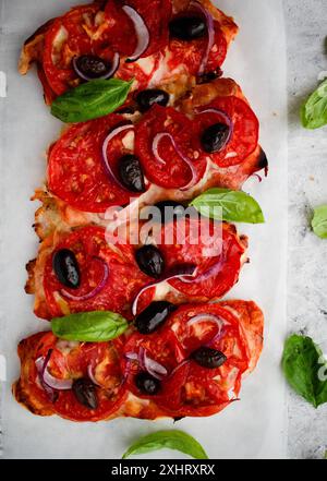 Bruschetta savoureuse à la mozzarella, tomates, olives noires et basilic sur un papier cuisson brun. Set d'encas italiens antipasti. Banque D'Images