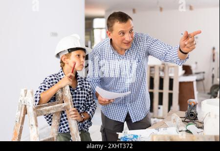 Père et fils parlant de planification de l'espace dans le nouvel appartement Banque D'Images