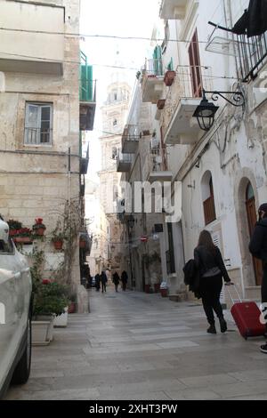 Les gens dans une rue étroite dans la vieille ville de Monopoli, Italie Banque D'Images