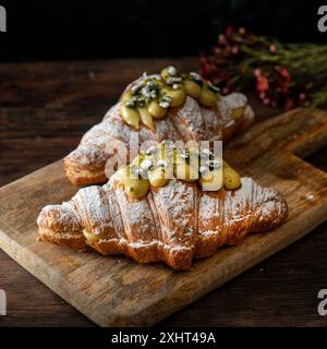 Croissants gourmands à la pistache fraîchement cuits sur un fond wodden. Style de vie du café-restaurant. Banque D'Images