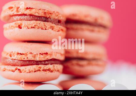 Macarons . Pâtisseries roses sucrées. Set de gâteaux aux macarons. Boîte en carton blanche remplie de macarons roses sur fond rose. Ensemble de pâtisseries françaises Banque D'Images