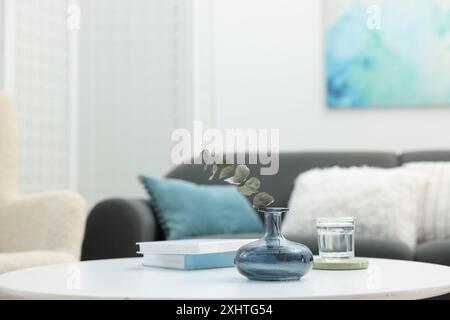 Table basse avec livres et décor près du canapé dans le salon, gros plan Banque D'Images