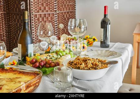 Une élégante table de vacances Shavuot avec du vin, du fromage, des fruits et des décorations de vacances, prête pour un repas de vacances juif traditionnel. Joyeux Shavuot inscript Banque D'Images