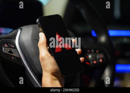 Hong Kong, Chine. 04 juillet 2024. Dans cette illustration photo, le logo de Mitsubishi est vu sur un écran de smartphone avec un volant en arrière-plan. Crédit : SOPA images Limited/Alamy Live News Banque D'Images