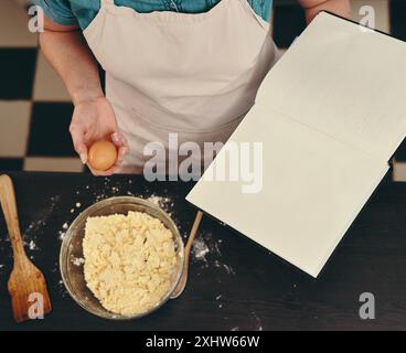 Mains, personne ou espace à livre ouvert pour recette pour la méthode de cuisson, dîner ou guide à la maison. Vue de dessus, instruction et chef avec cahier pour le menu Banque D'Images