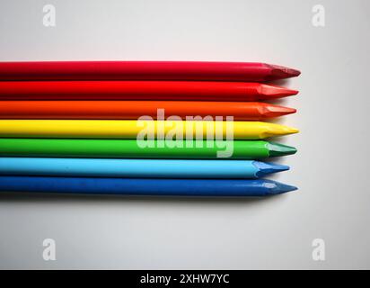 Photo de crayons de couleur disposés dans les couleurs de l'arc-en-ciel sur fond blanc. Crayons sans bois. Les crayons sont placés au milieu, horizontalement Banque D'Images