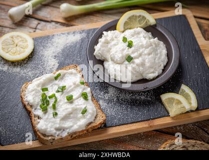 Délicieuse pâte à tartiner aux œufs de poisson maison étalée sur du pain avec des oignons verts et du citron Banque D'Images