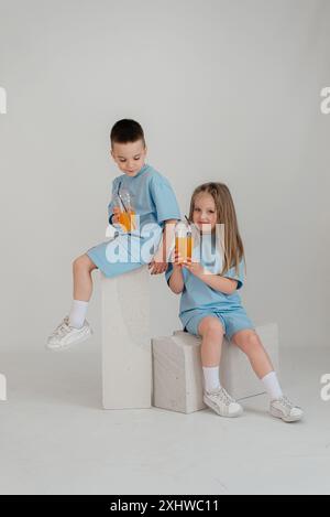 Un couple d'enfants dans des costumes identiques s'amusent dans le studio. Banque D'Images