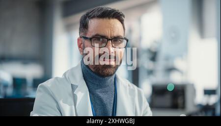 Portrait d'un bel homme portant des lunettes et une blouse de laboratoire regardant l'appareil photo. Ingénieur senior poursuivant une carrière scientifique. Expert de laboratoire professionnel et performant posant en toute confiance Banque D'Images