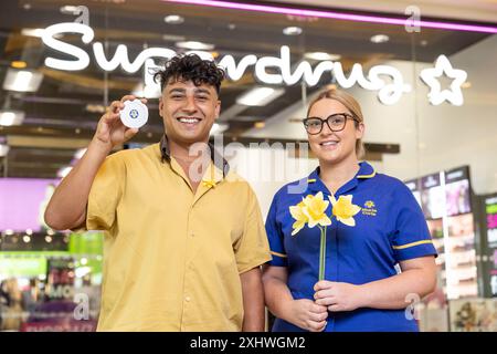 À USAGE ÉDITORIAL EXCLUSIF L'acteur Karim Zeroual et l'infirmière principale Marie Curie Sophie Graham lors du lancement de l'initiative de collecte de fonds Yellow Pennies à Superdrug, Manchester, exhortant les acheteurs à compléter leurs achats de 20p pour faire un don à l'œuvre vitale de la principale association caritative britannique de fin de vie. Date d'émission : mardi 16 juillet 2024. Banque D'Images