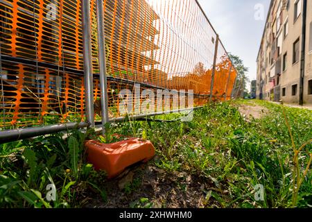 Pied de clôture en plastique creux pour la stabilité panneaux de clôture en fil métallique temporaire, espace confiné avec orange, plastique, maille de sécurité placée autour de la nouvelle finition Banque D'Images