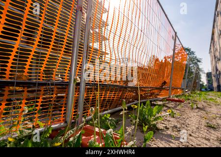 Pied de clôture en plastique creux pour la stabilité panneaux de clôture en fil métallique temporaire, espace confiné avec orange, plastique, maille de sécurité placée autour de la nouvelle finition Banque D'Images