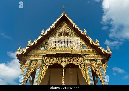 Pignon orné d'une salle de prière du temple Wat Plai Laem, Koh Samui, ciel bleu Thaïlande, été Banque D'Images