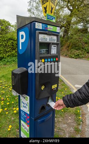 Homme personne achetant le billet du parcmètre au parking payant et affichage Angleterre Royaume-Uni GB Grande-Bretagne Banque D'Images
