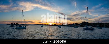 Vue panoramique des yachts amarrés sur des bouées près de la rive dans la baie d'Uvala Gradina près de la ville de Vela Luka sur l'île de Korcula au coucher du soleil Banque D'Images