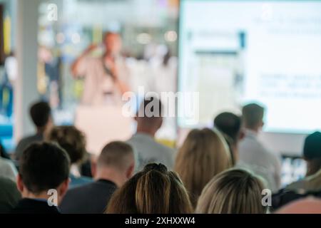 Groupe de personnes écoutant attentivement un orateur lors d'un séminaire d'affaires ou d'une présentation. L'orateur est concentré pendant qu'il donne une conférence. Banque D'Images